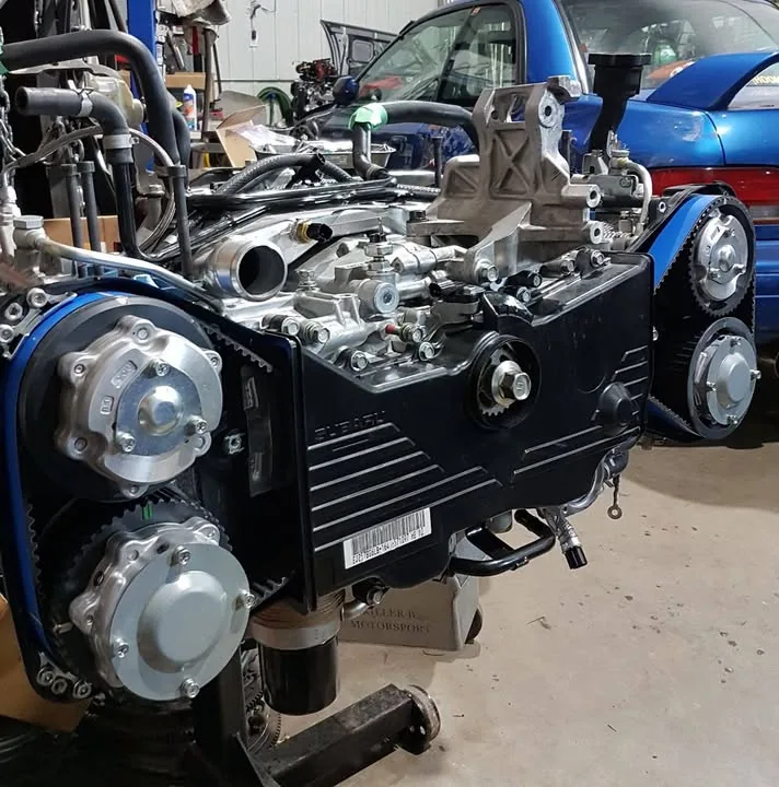 Un moteur boxer Subaru en préparation dans l'atelier, courroies de distribution bleues